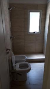 a small bathroom with a toilet and a window at La Paloma Chapadmalal in Mar del Plata