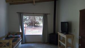 a living room with a window and a tv at La Paloma Chapadmalal in Mar del Plata