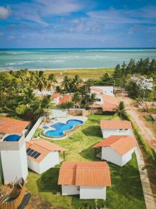 an aerial view of a resort with a pool and the ocean at Parada IT in Japaratinga