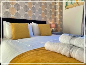 ein Schlafzimmer mit einem großen weißen Bett mit gelben Kissen in der Unterkunft Smugglers Rest Bed & Breakfast in Whitby