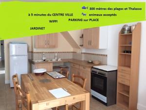 a kitchen with a wooden table in a kitchen at maison située à 300 mètres de la thalasso de Pornic et des plages in Pornic +34 photos