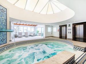 a large swimming pool in a house with a skylight at Hotel Cassino Tower Campinas Cambuí in Campinas