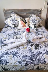 deux cygnes sur un lit avec une fleur sur celui-ci dans l'établissement La villa IXORAS, à Le Robert