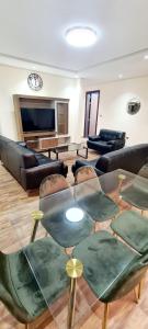 sala de estar con mesa de cristal y sillas en HAVANA HOLIDAY HOMES MIRDIF en Dubái