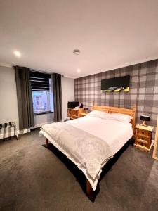 a bedroom with a large bed and a television at MacArthur House NC500 in Wick