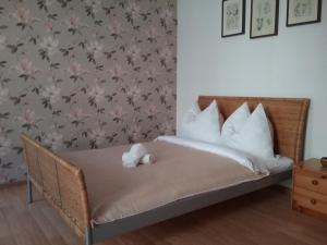 a bed with white pillows and a wall with flowers at POKOJE MŁODZIEŻOWE in Toruń