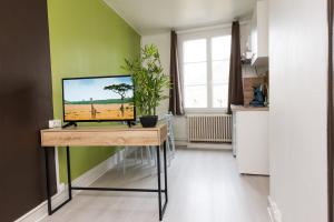 a kitchen with a table with a television on it at La Savane - Dormir Comme à la maison - in Châteaubriant