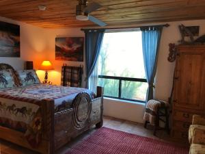 a bedroom with a bed and a large window at Spur Cross Inn in Cave Creek