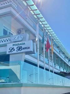 a sign on the side of a building with flags at Pousada La Barca in Torres