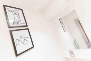 a bathroom with two framed pictures and a mirror at Modern Apartment in Salford Manchester UK in Manchester