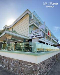 a building with a sign on the side of it at Pousada La Barca in Torres