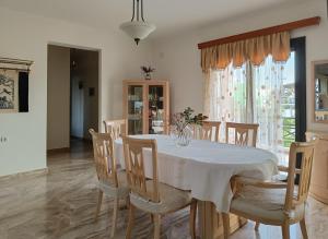 a dining room with a white table and chairs at Spacious House in a Quiet Neighbourhood in Ierapetra