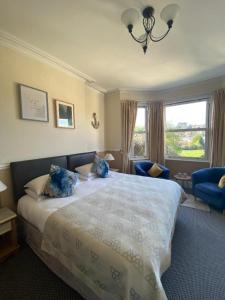 a bedroom with a large bed with blue pillows at Buckingham Lodge Guest House in Torquay