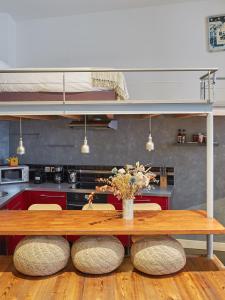 une cuisine avec une table en bois et deux tabourets dans l'établissement Loft - L'Hôtel Particulier, à Bordeaux