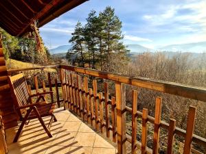 a porch with a chair and a view of the mountains at Romantic Cottage House in Žužemberk