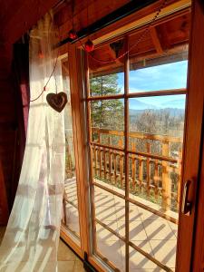 una ventana con un corazón colgando de una cortina en Romantic Cottage House, en Žužemberk