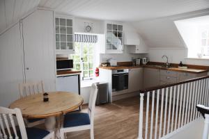 a kitchen with a wooden table and a dining room at Central Location - Riverside - Cosey Cottage - Close to Beaches in Christchurch