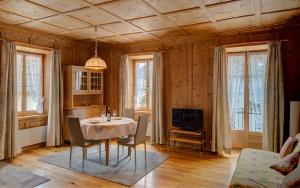a dining room with a table and chairs and a tv at Casa Zanetti in Le Prese