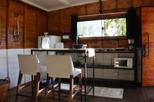 y cocina con mesa, sillas y fogones. en Rancho VSS Cabana da Montanha 1 en Nova Petrópolis