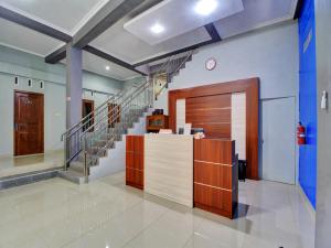 a lobby with a staircase and a reception desk at Super OYO 90767 Gm Guest House in Wonogiri