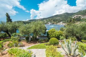 a garden with a view of the water and a harbor at kala.mia charming sea view villa in Kalami