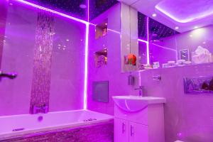 a purple bathroom with a tub and a sink and a tubermott at Meridian Serviced Apartments in Bradford