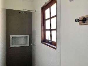 a bathroom with a shower and a window at Pousada Catamara in Arraial d'Ajuda