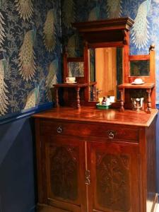 une armoire en bois avec un miroir au-dessus dans l'établissement Riverside Cottage at Logwood Mill, à Ballyclare