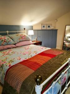 Ballyclare的住宿－Riverside Cottage at Logwood Mill，一间卧室配有一张带花被的床