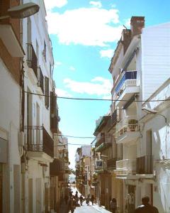 um grupo de pessoas andando por uma rua com edifícios em BONAIRE em Sitges