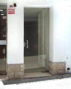 uma entrada para um edifício com uma porta de vidro em BONAIRE em Sitges