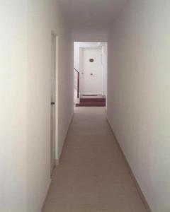 um corredor vazio com uma parede branca e uma porta branca em BONAIRE em Sitges