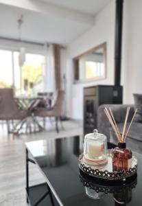 a living room with a table with a candle and cinnamon sticks at Oasis Citadine Terrasse intime jardin privatif en plein centre ville 70m2 in Cambrai