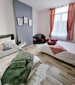 - une chambre avec 2 lits et une fenêtre dans l'établissement Oasis Citadine Terrasse intime jardin privatif en plein centre ville 70m2, à Cambrai