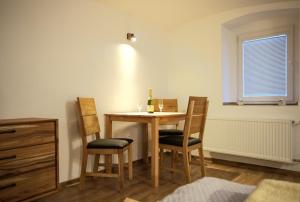 - une table à manger avec 2 chaises et une bouteille de vin dans l'établissement Apartmánek mezi kopci, à Jáchymov