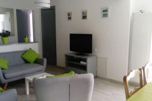 a living room with a couch and a flat screen tv at baratzean in Uhart-Cize
