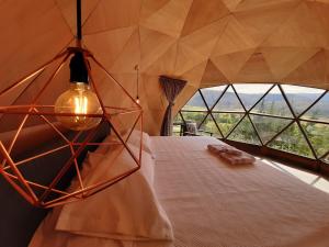 a bedroom with a bed with a large window at Glamping NIDO VERDE in Iza