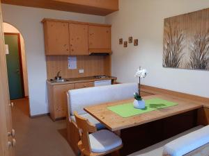 a kitchen with a wooden table with a vase on it at Casa AQ28 sulle piste da sci in Falcade