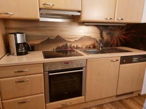 a kitchen with a stove top oven next to a sink at Ferienwohnung Lenz in Marktschellenberg