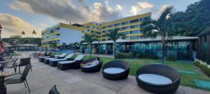 a hotel with couches and chairs in front of a building at Apartamento em Tabatinga in Conde