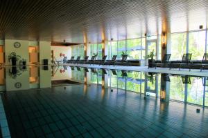 un edificio con una piscina con sillas. en Hotel Kaiseralm en Bischofsgrün