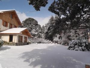 a driveway covered in snow next to a house at Hosteria Katy in San Carlos de Bariloche