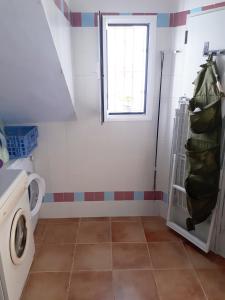 baño con lavadora y ventana en Mi Cachito, en Los Caños de Meca