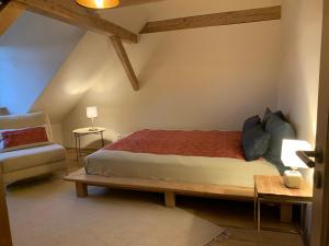a bedroom with a large bed and a chair at Kranichhof - Studio, Loft & Atelier in Zossen