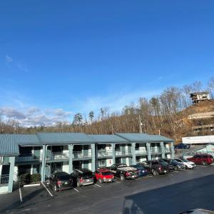 a parking lot with cars parked in front of a building at Country Town N' Suites in Gatlinburg
