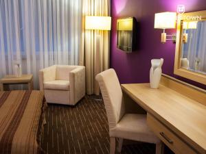 a hotel room with a bed and a desk and a chair at Grape Town Hotel - Park79 in Zielona Góra