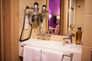 a bathroom with a sink with a phone at Grape Town Hotel - Park79 in Zielona Góra