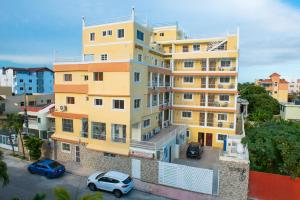 a yellow building with cars parked in front of it at Family 2 Bedroom Apartment in Corales del Sur in La Viva +3 photos