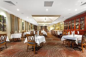 Mercure Maitland Monte Pio في ميتلاند: غرفة طعام مع طاولات وكراسي بيضاء