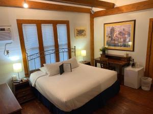 1 dormitorio con 1 cama grande y escritorio en The Garden House, en Key West